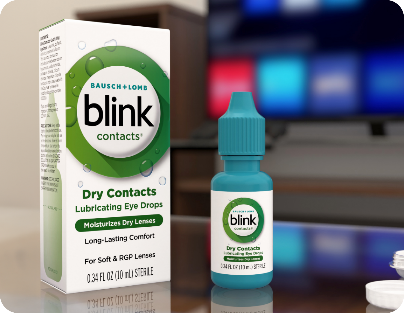 Blink Contacts Lubricating Eye Drops bottle and package on a desk in front of a computer monitor