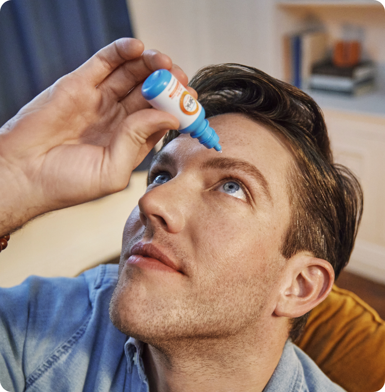 Man putting a drop of Blink Triple Care in his eye